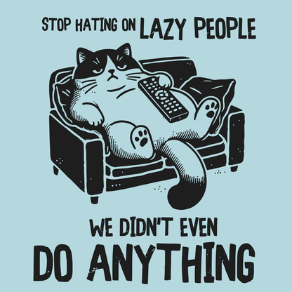 Novelty Fridge Magnet - Cartoon cat lounging on a couch with a remote, text 'Stop hating on lazy people, we didn't even do anything' on a light blue background.